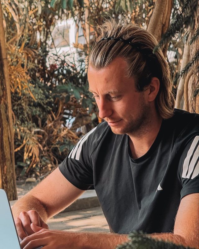 Julien en train de monter ses vidéos sur son ordinateur, dans un coworking en pleine nature
