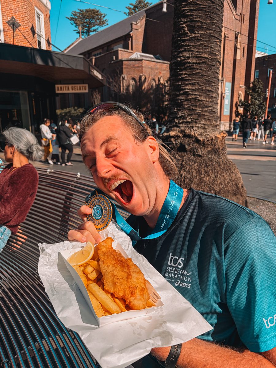 Julien avec sa médaille du marathon de Sydney devant une barquette de fish and chips