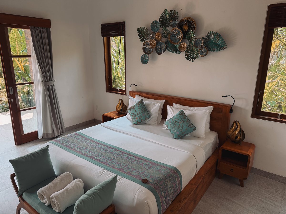 Chambre claire avec un grand lit et une décoration murale en feuilles de métal