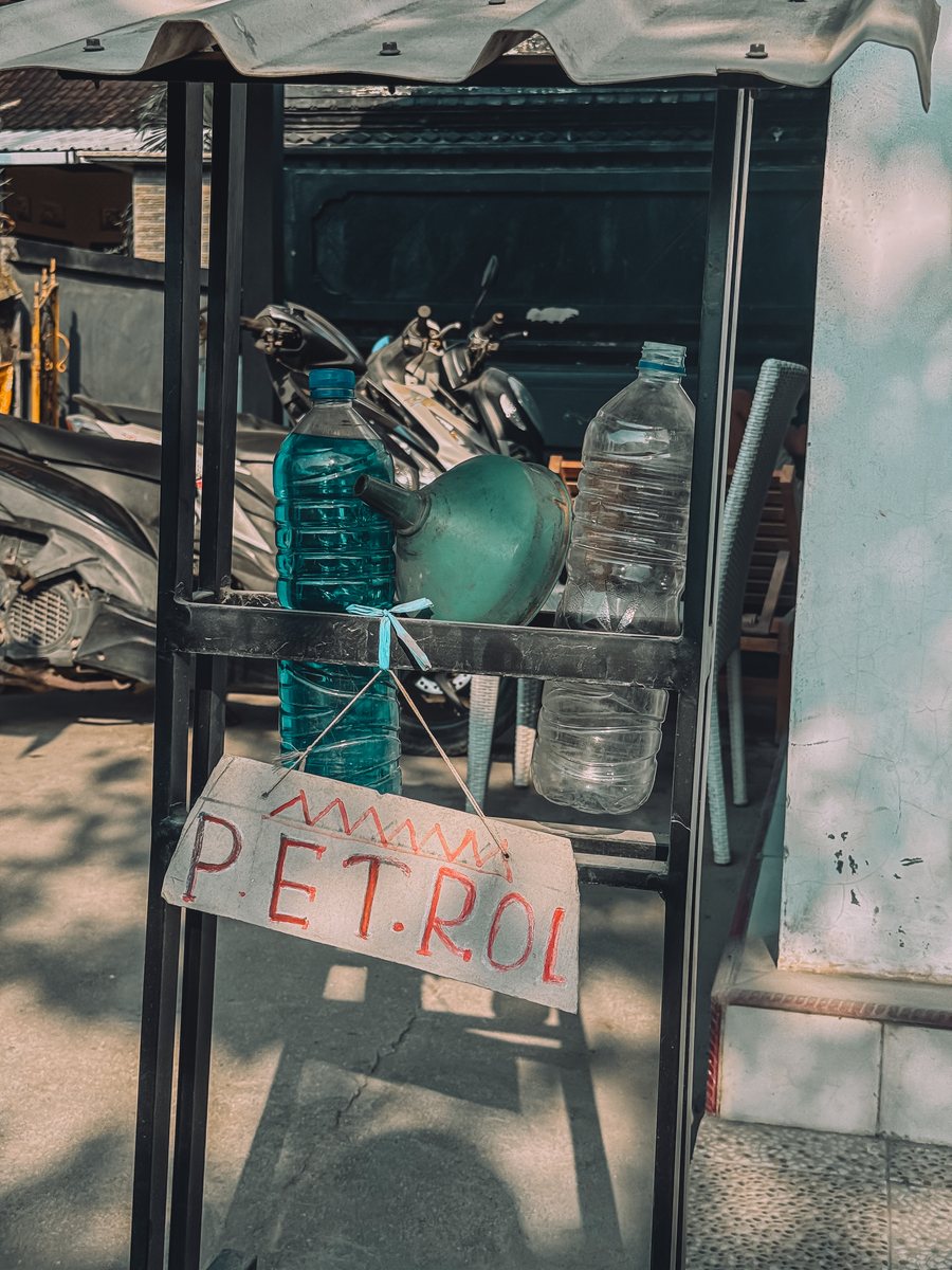 Un présentoir de bord de route vendant de l'essence en bouteilles de récupération