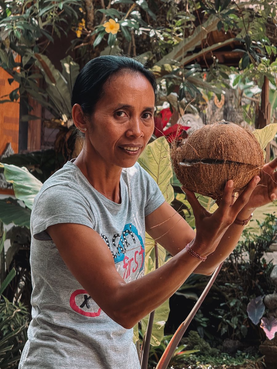 Notre guide balinaise tient une noix de coco ouverte, avant d'en extraire l'huile