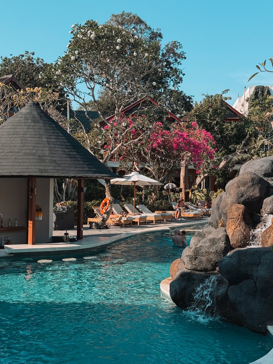 La piscine d'un hôtel avec un bar dans l'eau et une cascade de rochers