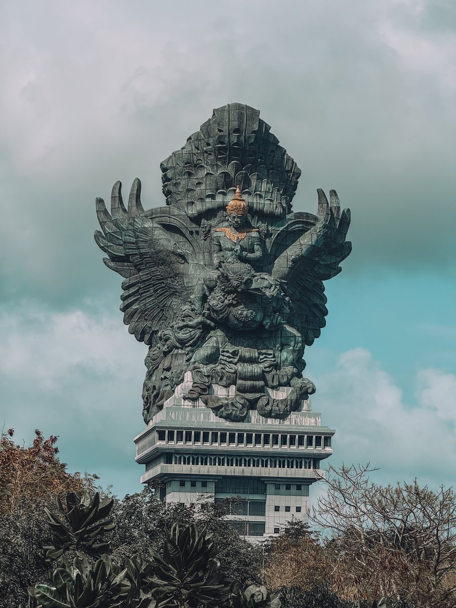La statue de Garuda Wisnu Kencana, Vishnu chevauchant l'aigle Garuda, dressée au dessus des arbres