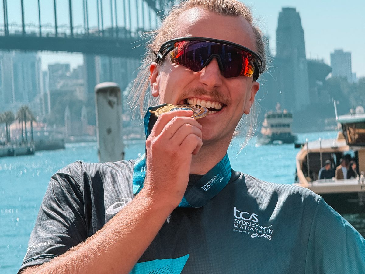 Julien mord sa médaille du marathon de Sydney, le port en arrière plan