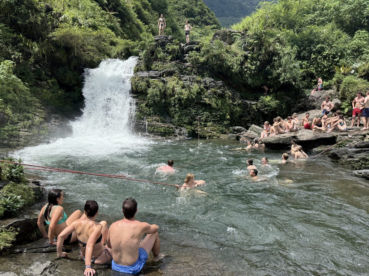Baignade collective au pied d'une cascade, au bord de la route