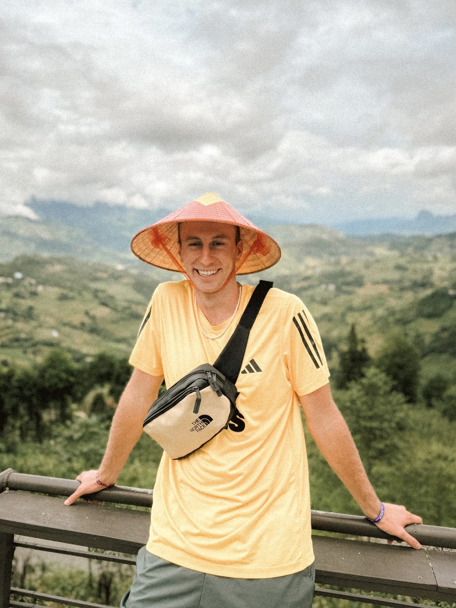Julien coiffé d'un chapeau conique vietnamien, à un point de vue