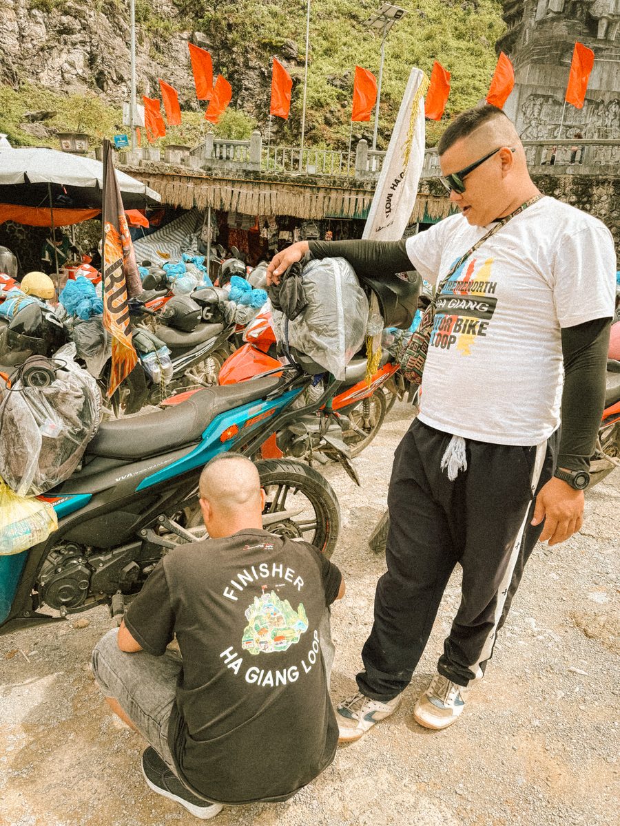Deux chauffeurs en t shirt Finisher Ha Giang Loop, devant les motos chargées