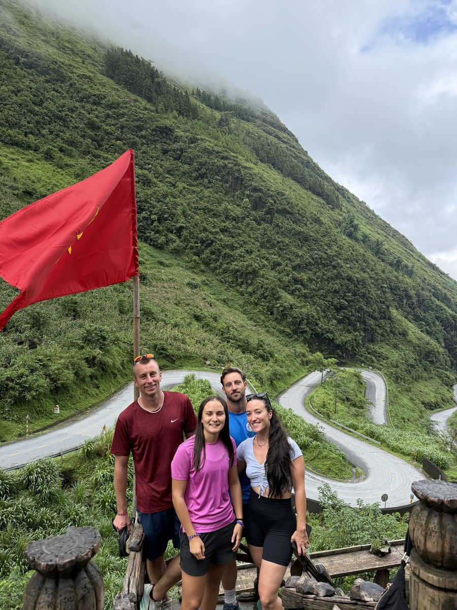Le groupe devant un drapeau vietnamien, la route en lacets derrière