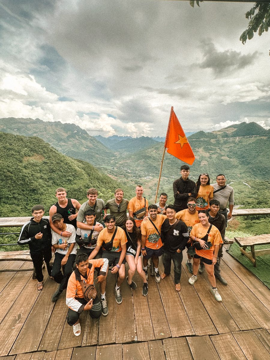 Le groupe réuni sur une terrasse en bois, drapeau vietnamien au vent
