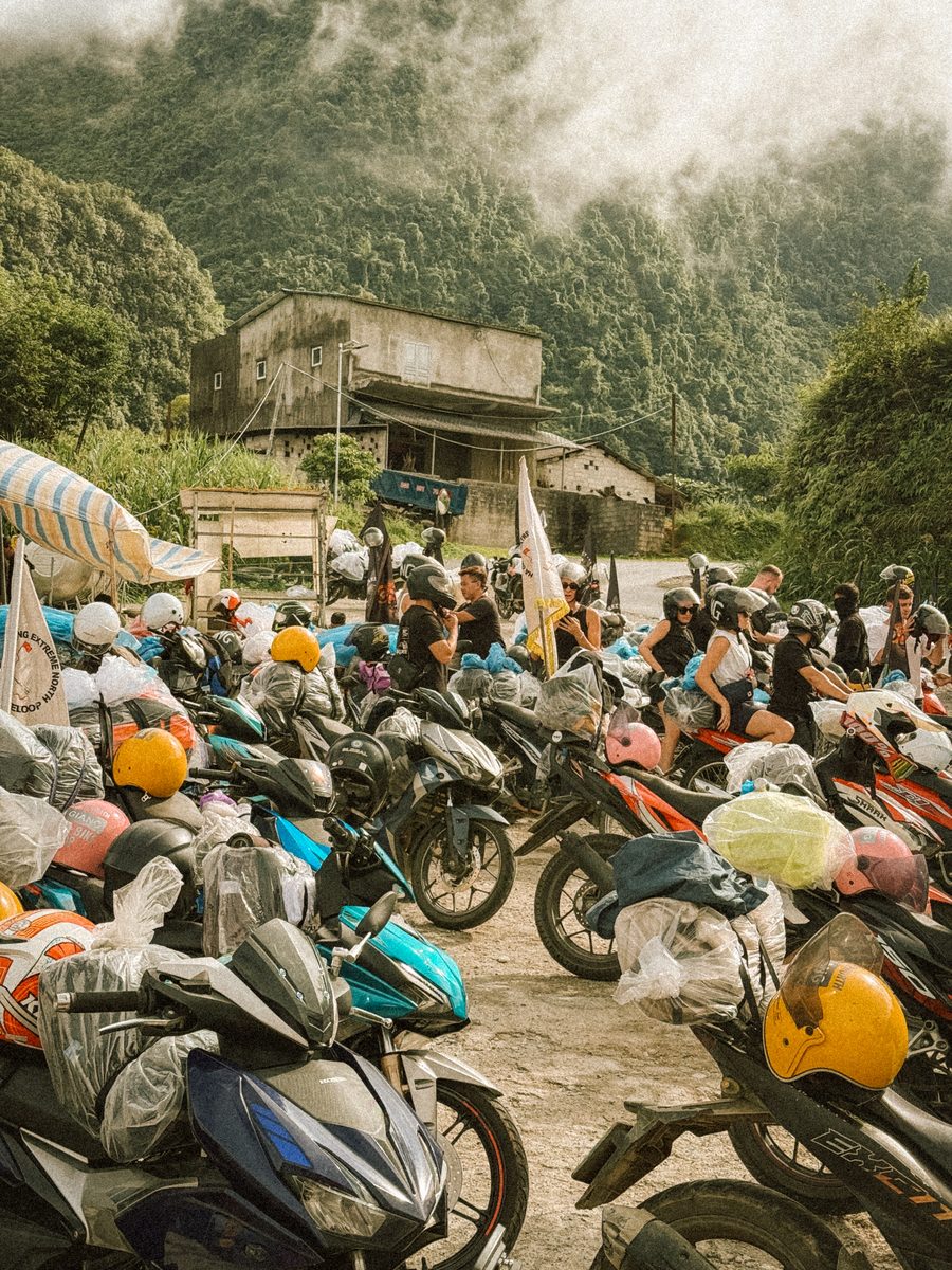 Des dizaines de motos bâchées sous la pluie, à l'arrêt devant une maison