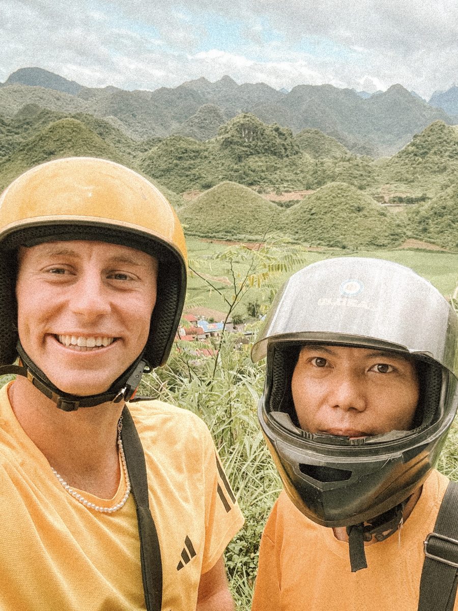 Julien et son chauffeur en selfie, casques sur la tête, les karsts derrière