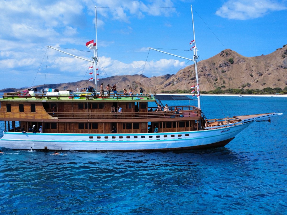 Bateau traditionnel indonésien à l'ancre devant les collines du parc national de Komodo