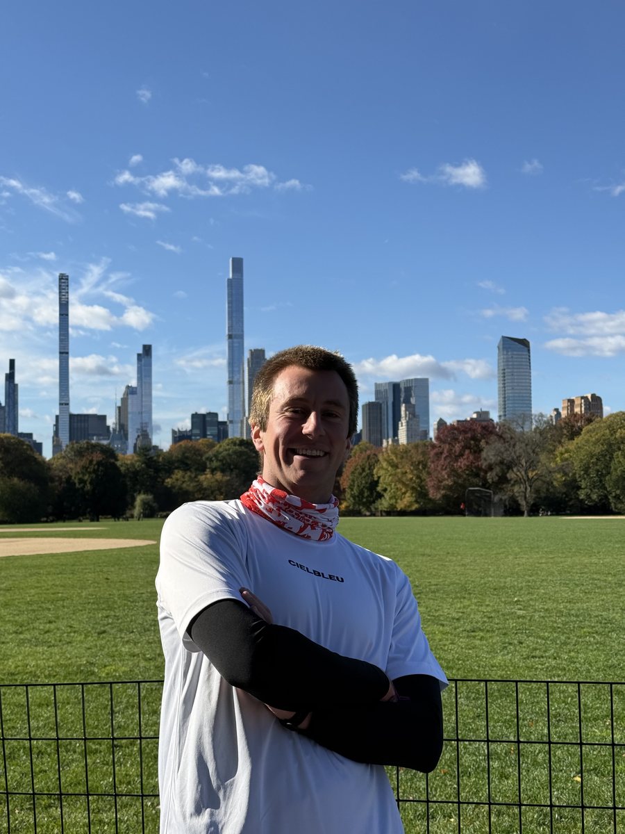 Julien en tenue de running dans Central Park, les tours de Midtown en arrière plan