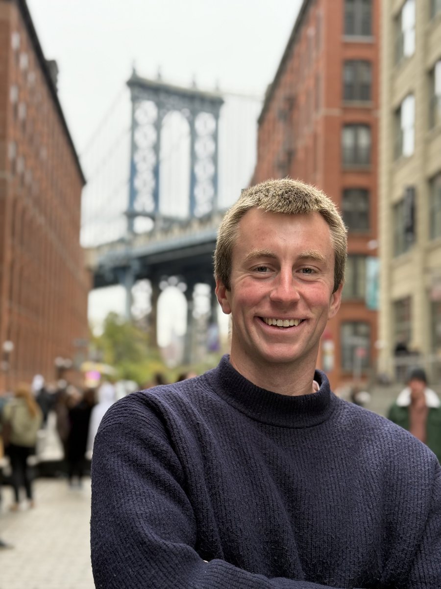 Julien devant le pont de Manhattan, encadré par les briques rouges de Dumbo