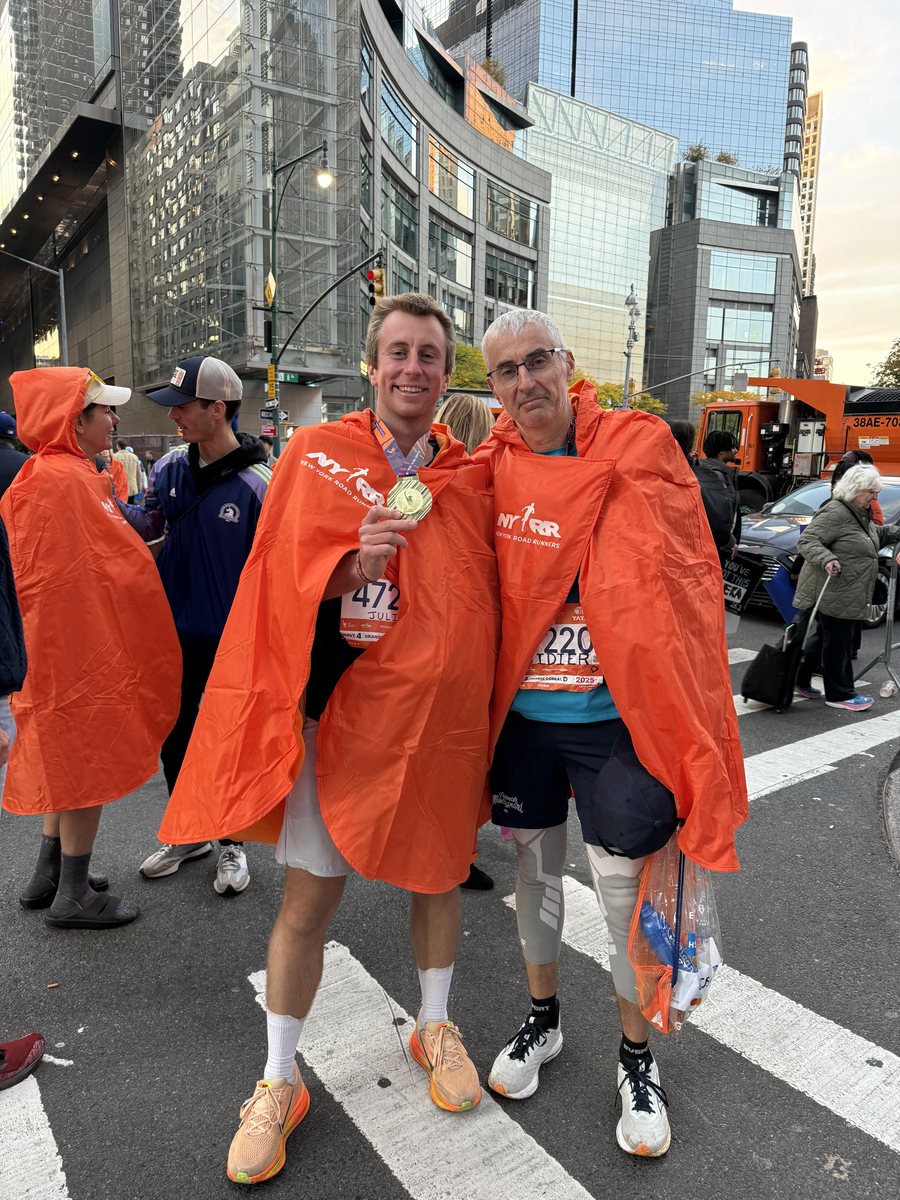 Deux finishers du marathon de New York, médaille au cou et poncho orange sur les épaules