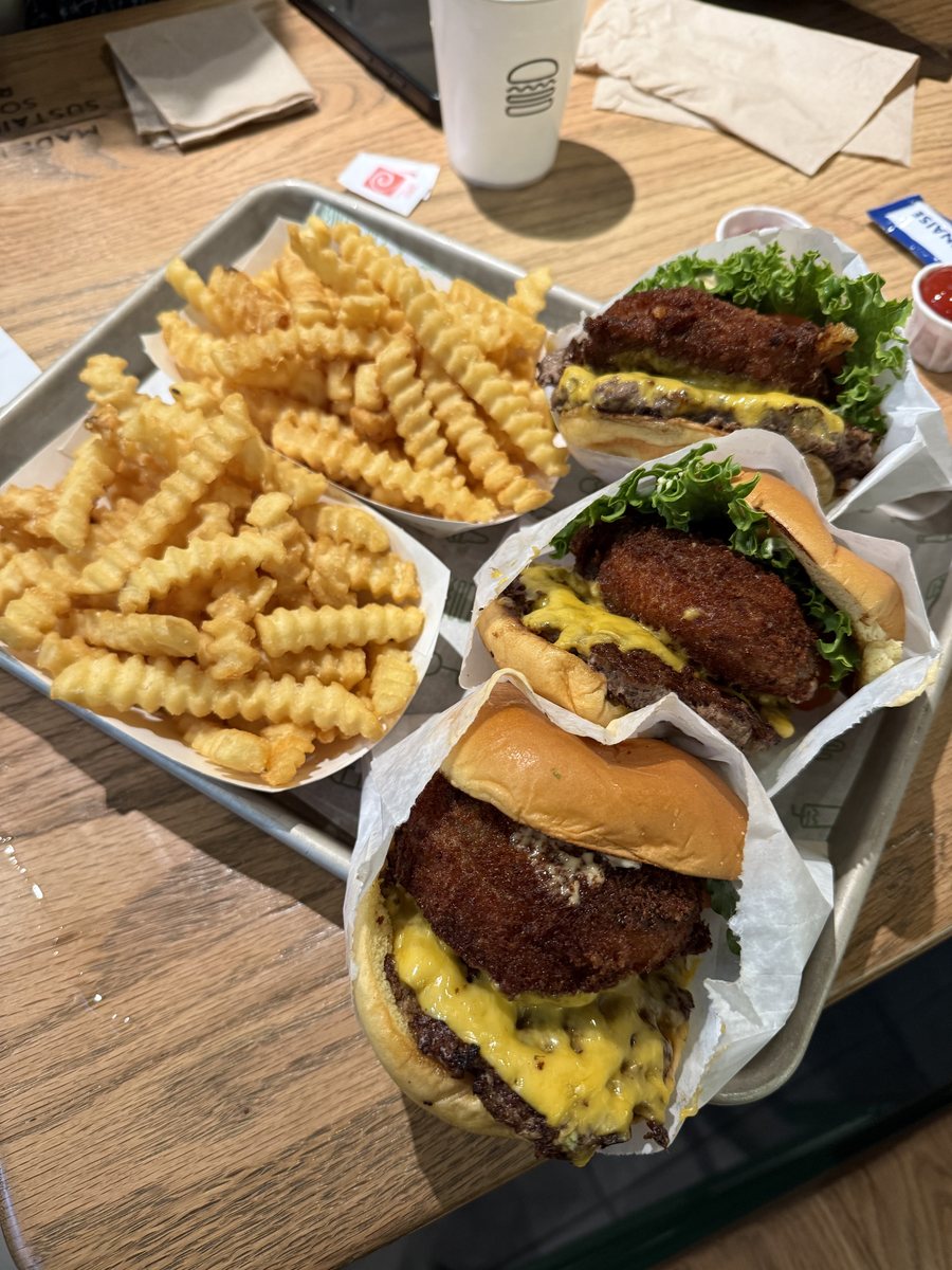 Plateau de burgers et de frites gaufrées, sur une table en bois