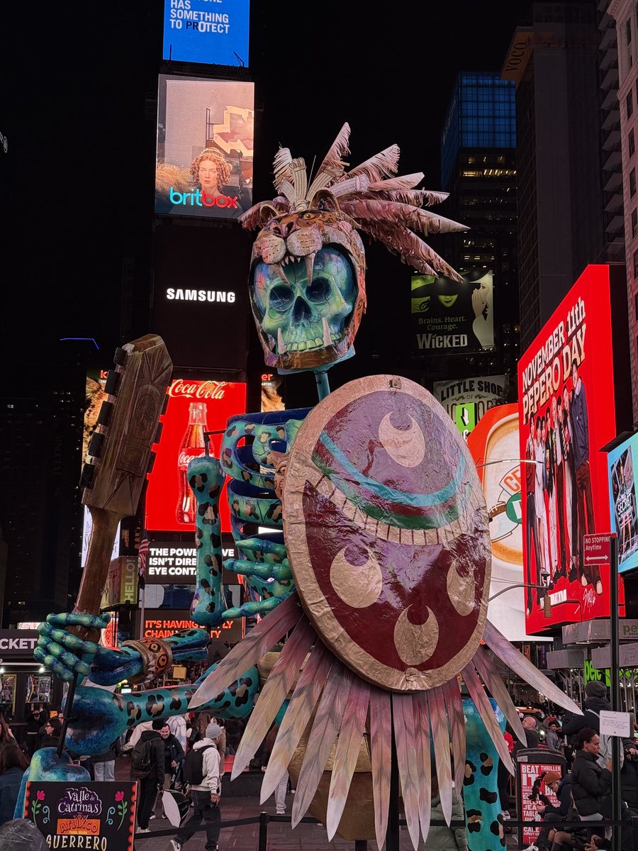 Grande sculpture de squelette illuminée au milieu des écrans de Times Square, la nuit
