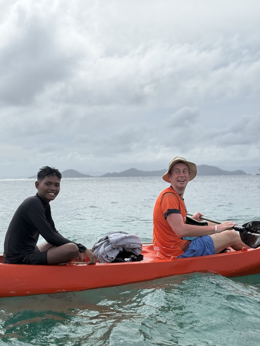 Deux personnes dans un kayak orange, au large d'un chapelet d'îles