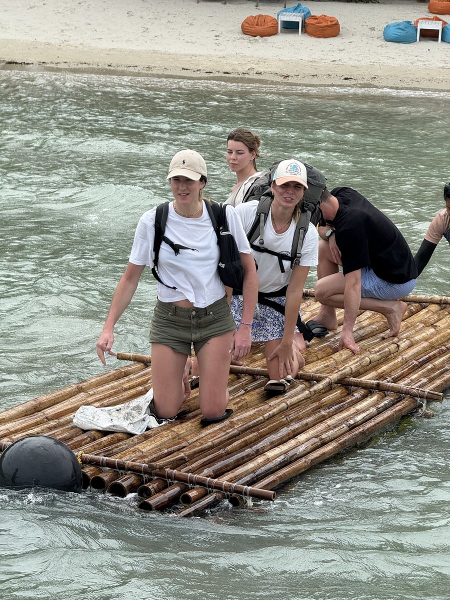 Traversée sur un radeau de bambou tiré à la corde, sacs sur le dos