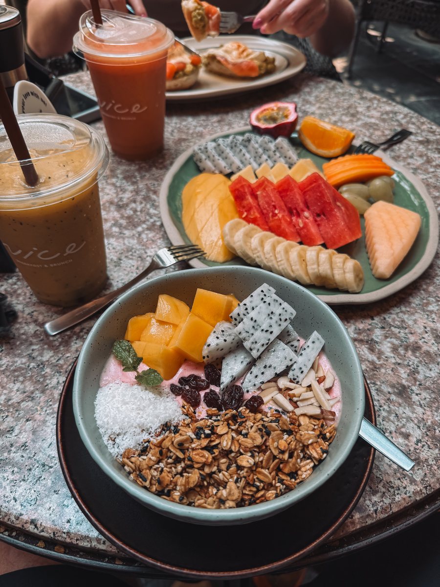 Smoothie bowl et assiette de fruits tropicaux sur une table de café