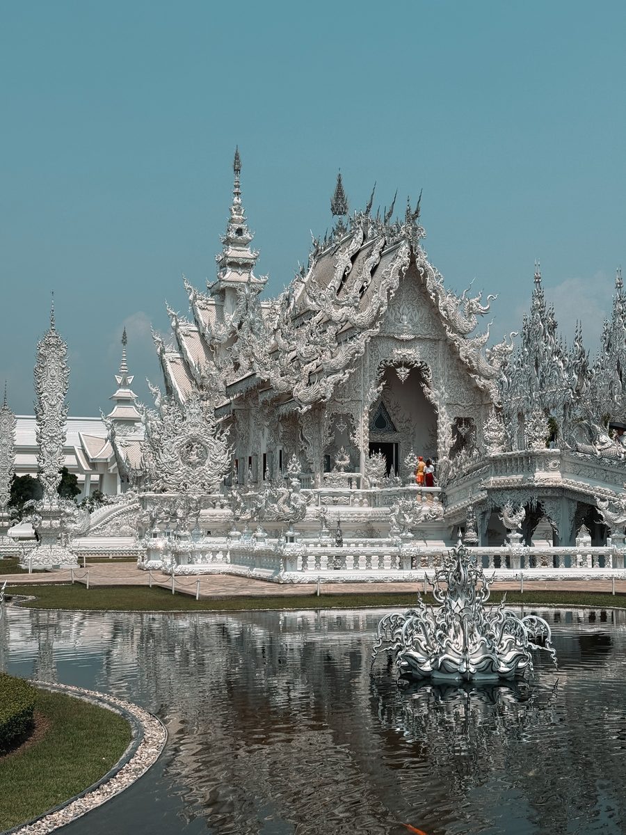 Le Temple Blanc de Chiang Rai et son bassin, sculpté de dentelle blanche et de miroirs