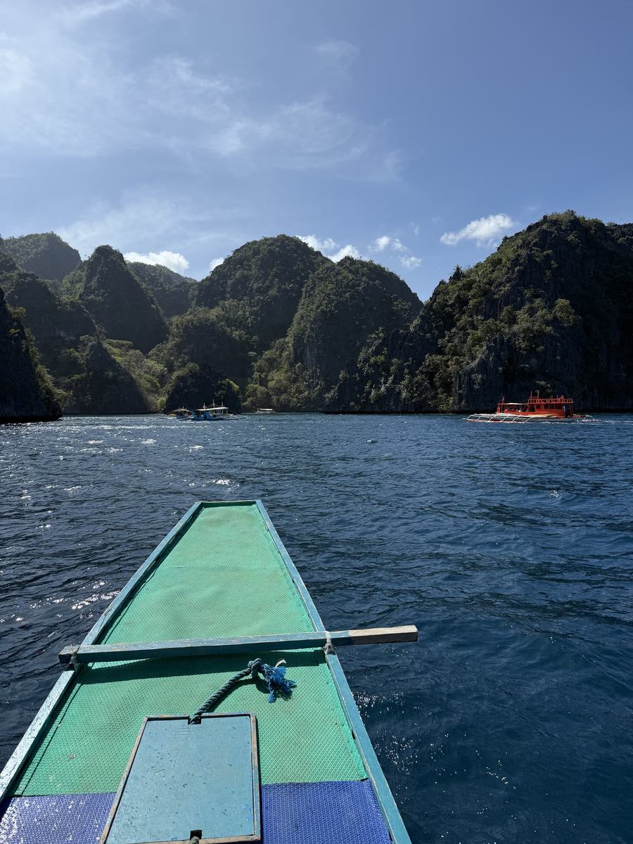 Proue d'un bangka en bois face aux pitons calcaires de Coron